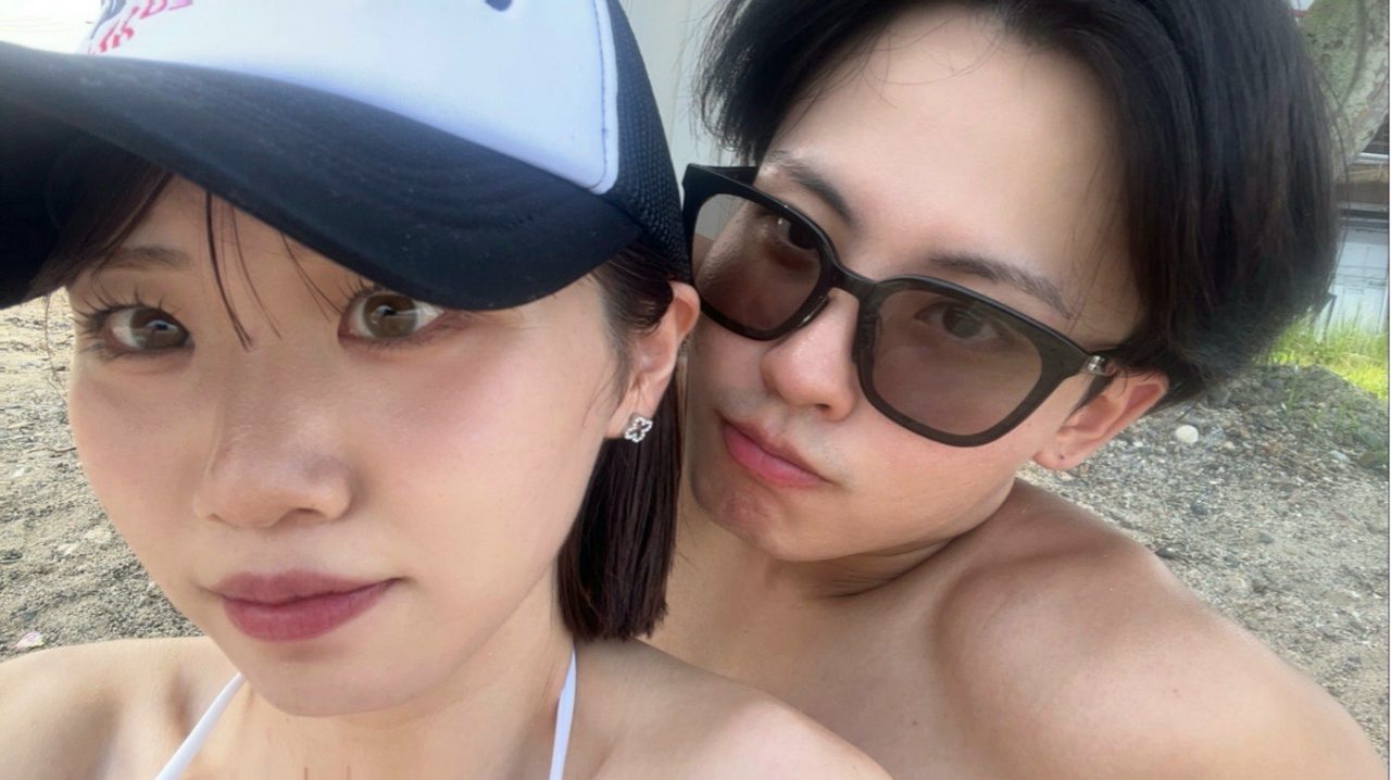帽子とサングラスで顔を寄せるふたり